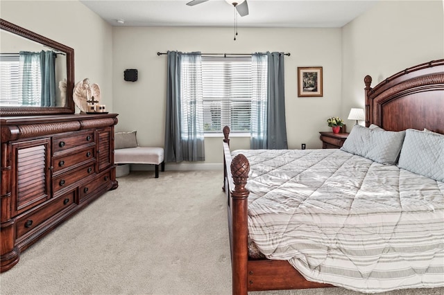 bedroom featuring light carpet, multiple windows, and a ceiling fan