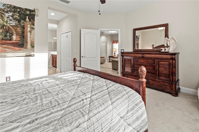 bedroom featuring baseboards, visible vents, light colored carpet, ensuite bath, and a closet