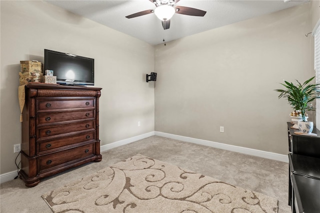 bedroom featuring a ceiling fan, light carpet, and baseboards