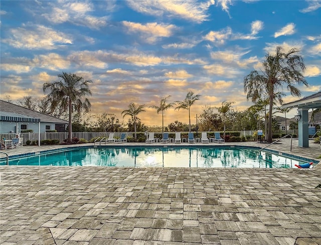 pool with a patio area and fence