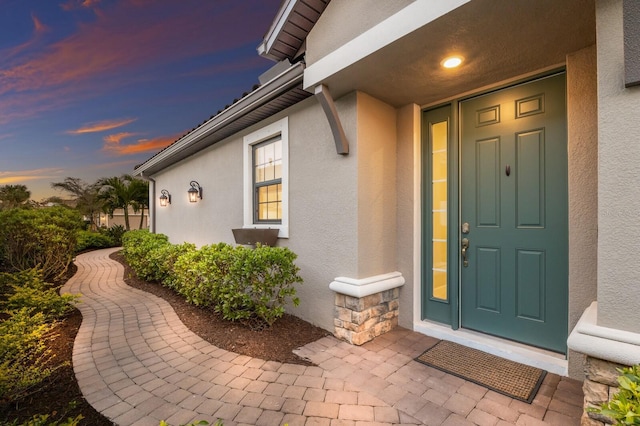 entrance to property with stone siding and stucco siding