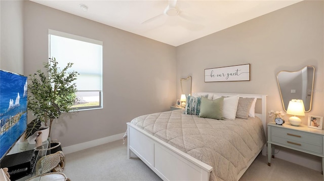 bedroom featuring a ceiling fan, light carpet, and baseboards