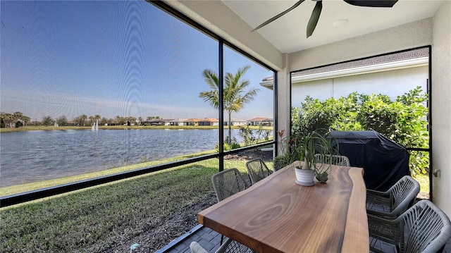 sunroom / solarium featuring a water view and ceiling fan