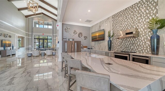 kitchen with wall chimney exhaust hood, light stone counters, marble finish floor, stainless steel electric stove, and a sink