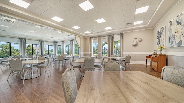 dining space featuring a paneled ceiling, wainscoting, wood finished floors, and visible vents