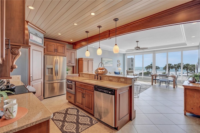 kitchen with light tile patterned floors, appliances with stainless steel finishes, a sink, and a center island with sink