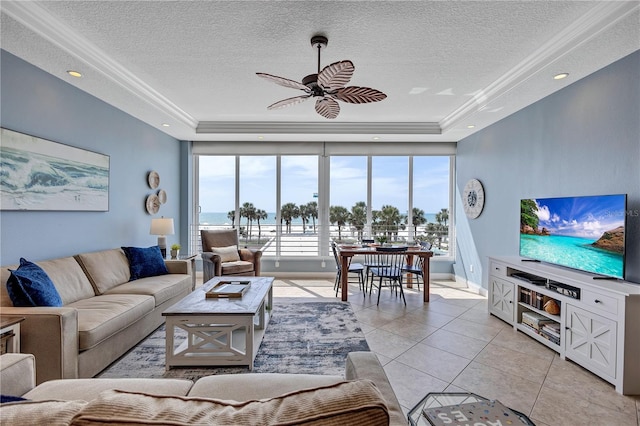 living area with a textured ceiling, light tile patterned floors, and a raised ceiling