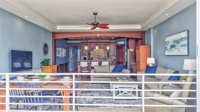 interior space with a ceiling fan, recessed lighting, a raised ceiling, and ornamental molding