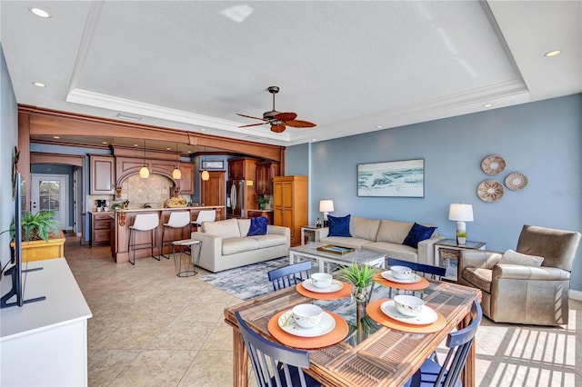 living area with a ceiling fan, recessed lighting, a raised ceiling, and crown molding