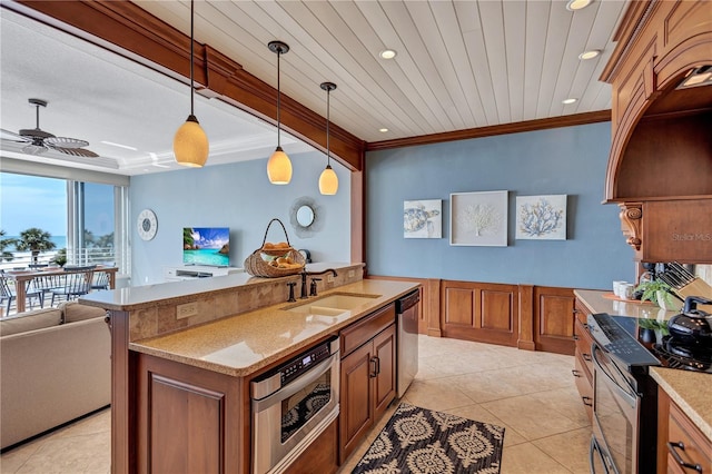 kitchen with stainless steel appliances, brown cabinetry, ornamental molding, open floor plan, and a sink