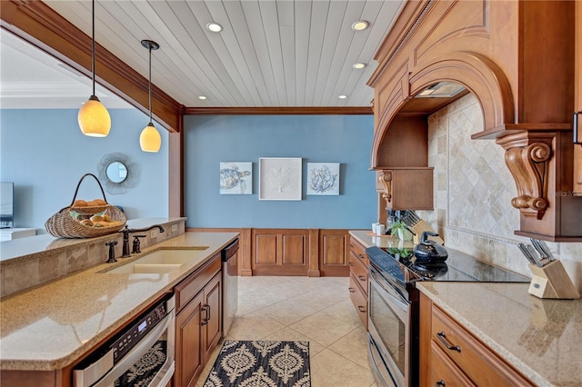 kitchen with stainless steel appliances, hanging light fixtures, brown cabinetry, ornamental molding, and a sink