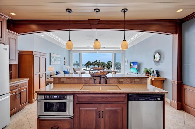 kitchen with appliances with stainless steel finishes, open floor plan, ornamental molding, and light tile patterned floors