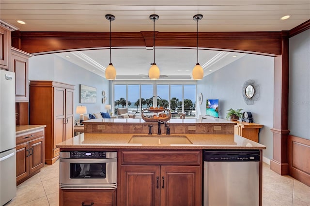 kitchen with light tile patterned flooring, open floor plan, ornamental molding, appliances with stainless steel finishes, and decorative light fixtures