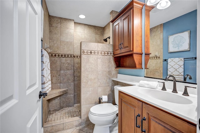 bathroom featuring toilet, a walk in shower, and vanity