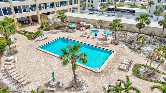 community pool with a patio and fence