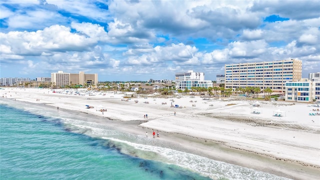 drone / aerial view with a water view, a beach view, and a city view