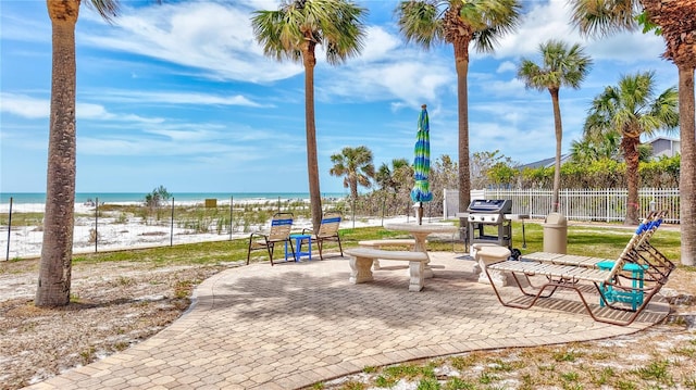 view of home's community with a view of the beach, a water view, and fence