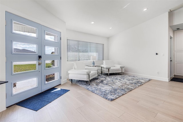 living area with recessed lighting, baseboards, wood finished floors, and french doors