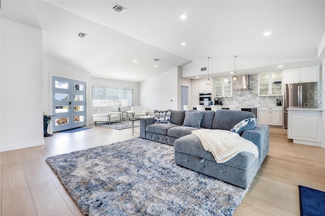 living area with lofted ceiling, light wood-style floors, visible vents, and recessed lighting