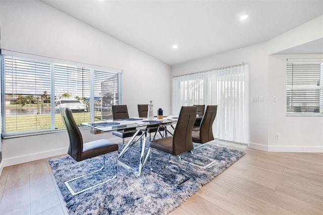 dining room with lofted ceiling, baseboards, and wood finished floors