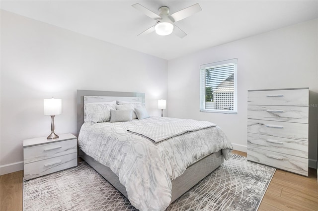 bedroom with a ceiling fan, baseboards, and wood finished floors