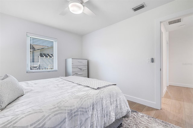 bedroom featuring wood finished floors, visible vents, and baseboards