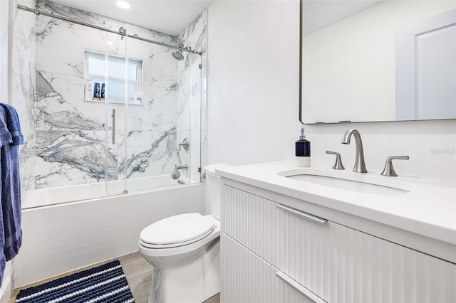 full bath featuring toilet, combined bath / shower with glass door, wood finished floors, and vanity