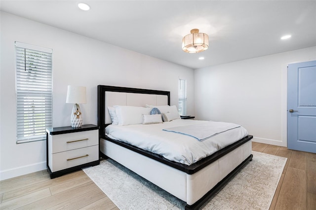 bedroom with light wood-style floors, baseboards, and recessed lighting