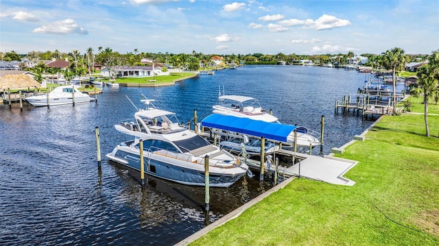 dock area with a water view, a lawn, and boat lift