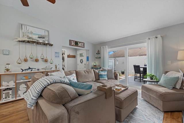 living area with vaulted ceiling, wood finished floors, and a ceiling fan