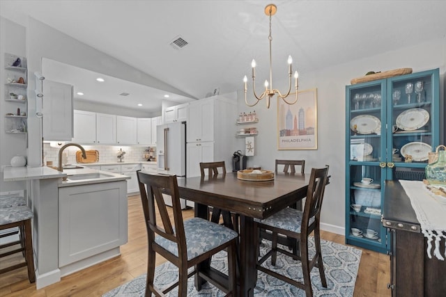 dining space with light wood finished floors, visible vents, lofted ceiling, a chandelier, and recessed lighting