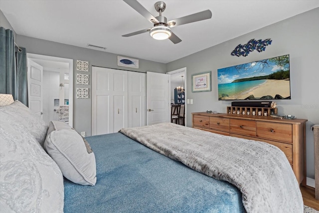 bedroom featuring a closet, visible vents, ceiling fan, and wood finished floors