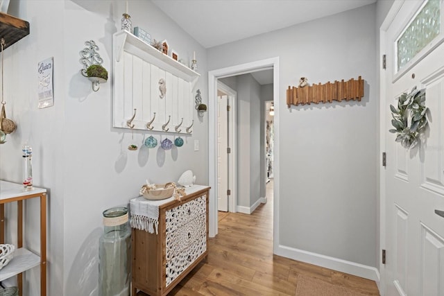 corridor with light wood-style floors and baseboards