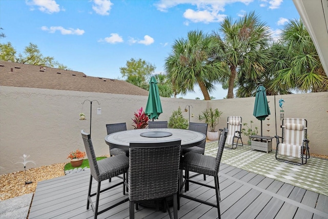 wooden deck with outdoor dining space and a fenced backyard