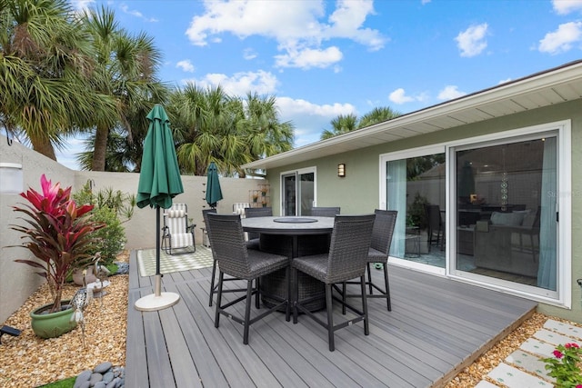 wooden deck with outdoor dining area and fence