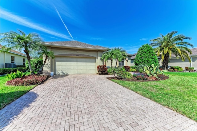 view of front facade featuring a garage, decorative driveway, a front lawn, and stucco siding