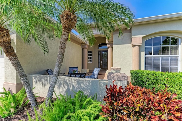 entrance to property featuring french doors and stucco siding