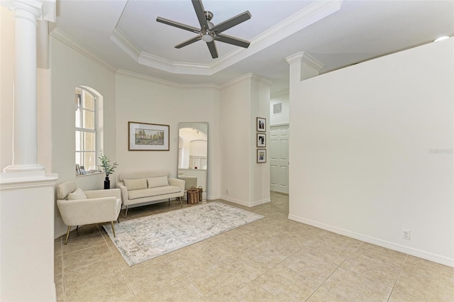 tiled living room featuring ornamental molding, a raised ceiling, decorative columns, and a ceiling fan