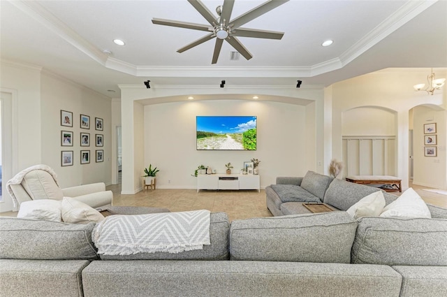 living area with arched walkways, a raised ceiling, crown molding, and recessed lighting