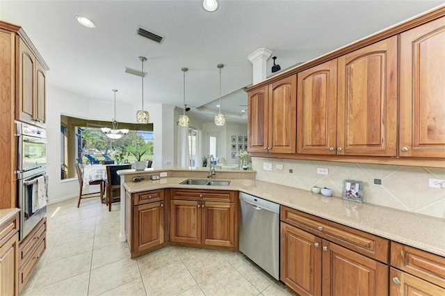 kitchen featuring visible vents, appliances with stainless steel finishes, brown cabinets, and a sink