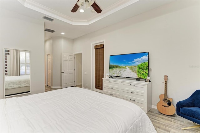 bedroom featuring visible vents, a raised ceiling, and ornamental molding