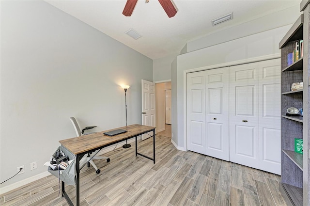 home office with a ceiling fan, visible vents, light wood-style flooring, and baseboards