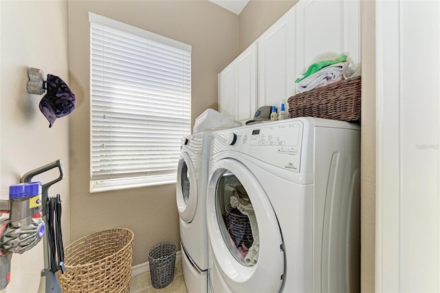 washroom featuring cabinet space, baseboards, and independent washer and dryer