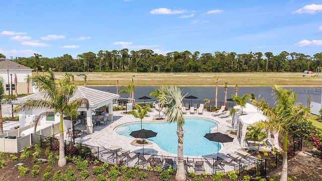 community pool featuring a water view, a patio area, fence, and a gazebo