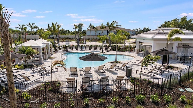 pool featuring fence and a patio