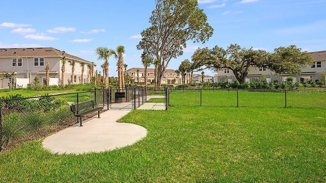 surrounding community featuring a gate, a residential view, fence, and a yard