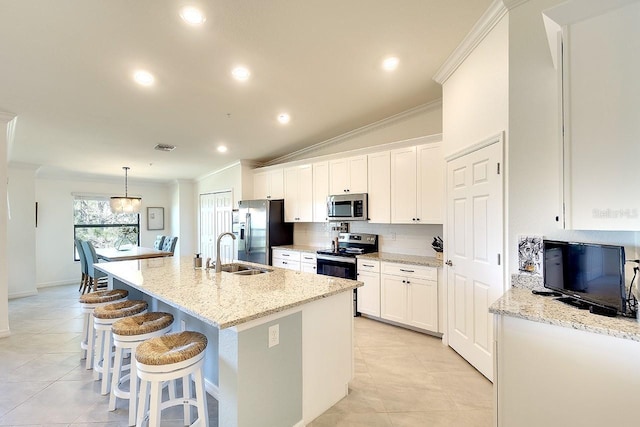 kitchen featuring an island with sink, a sink, stainless steel appliances, white cabinets, and crown molding