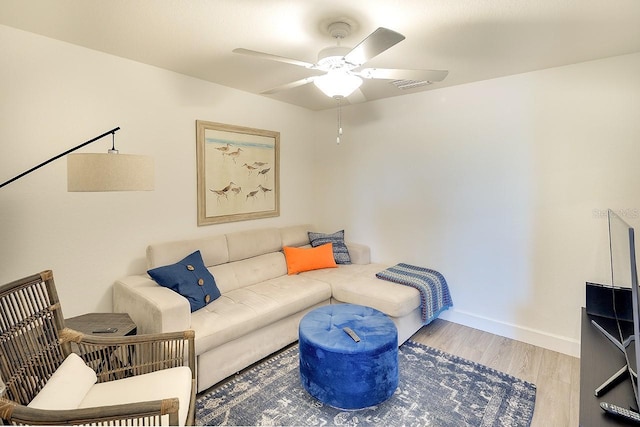 living room with wood finished floors, baseboards, and ceiling fan