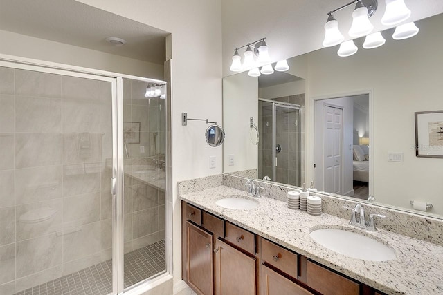 bathroom with a sink, double vanity, a stall shower, and ensuite bathroom