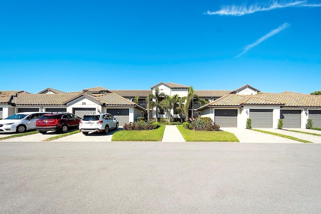 view of front of house with stucco siding, a residential view, driveway, and a tile roof